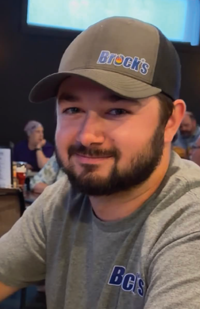 Ethan Bates in a Brock's hat and gray shirt